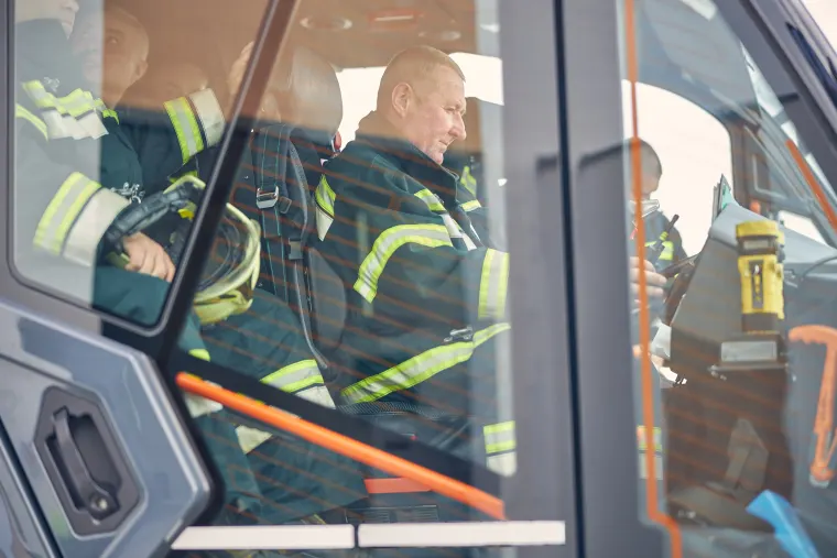 Un equipo de bomberos dentro de un vehículo de emergencia con equipo de protección, representando a las brigadas de protección civil en acción.