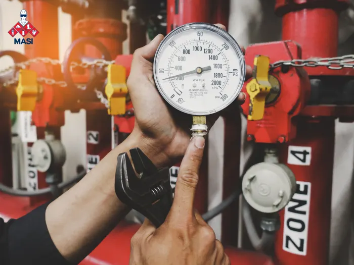 Toma visual de unas manos de técnico certificado realizando pruebas de presión en una bomba contra incendios para una seguridad industrial apta